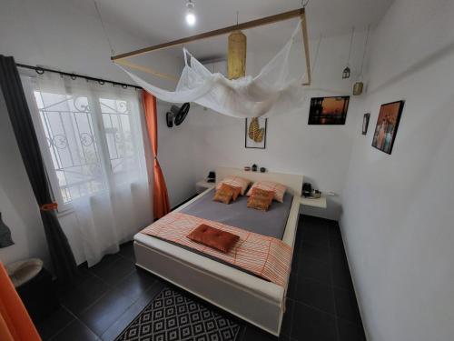 a small bedroom with a bed and a window at African Jaja villa Piscine-Climatisation in Poponguine