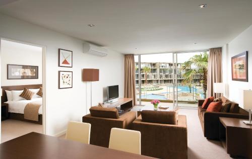 a living room with a bed and a dining room at Wyndham Resort Torquay in Torquay