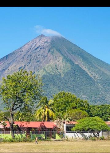 a mountain in the background with a building and trees at Beach cabin ometepe in Altagracia