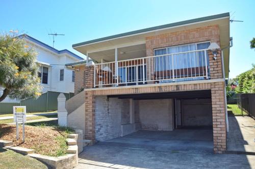 a brick house with a balcony and a garage at Adacos 19 On Sturt - Bring your own linen in South West Rocks