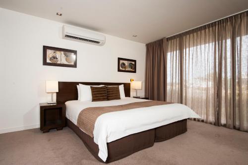 a bedroom with a large bed and a window at Wyndham Resort Torquay in Torquay