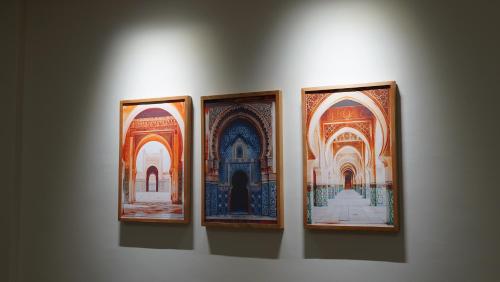 a group of four framed paintings on a wall at Suites El Ghailani in Dakhla