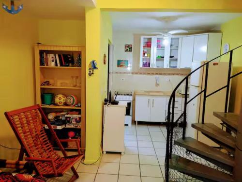 a kitchen with a white refrigerator and a white tile floor at Sobrado No5 in Matinhos
