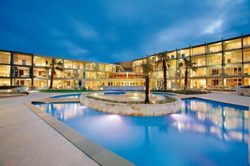 a building with a swimming pool in front of a building at Wyndham Resort Torquay in Torquay