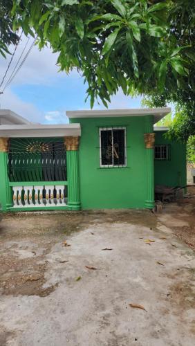 a green house with a window in a yard at Jade Coast Getaway Near Montego Bay in Montego Bay