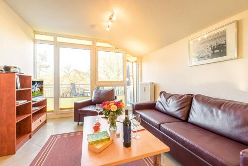 Una sala de estar con un sofá de cuero y una mesa. en Residenz Meeresblick A Fewo 4, en Rerik