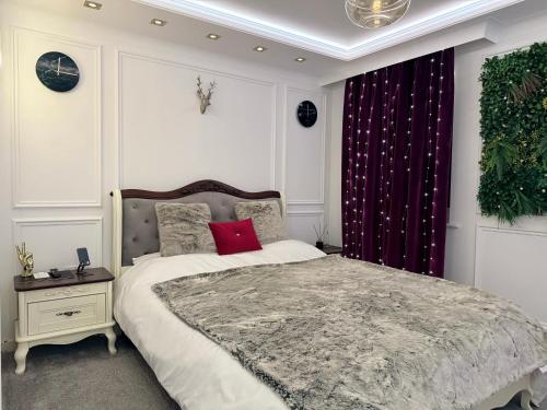 a bedroom with a large bed with a red pillow at Private Bedroom in Unique Luxury House, Salford, Manchester in Manchester