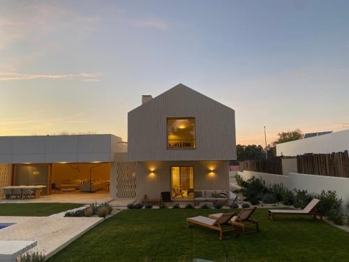 a modern house with a backyard with a lawn at Casa da Cúpula in Comporta