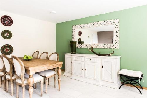 a dining room with a table and a mirror at Wildgrün Panorama Lodge 8b in Pfronten