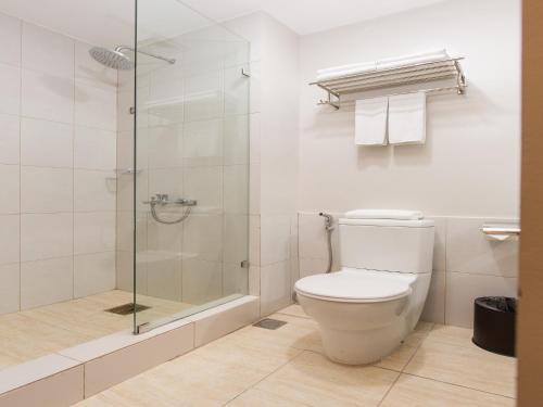 La salle de bains est pourvue de toilettes et d'une douche en verre. dans l'établissement MJ Hotel and Suites, à Cebu