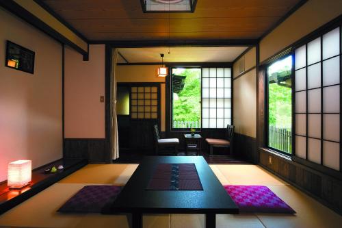 Pokój ze stołem i oknami w obiekcie Nanakamado w mieście Kokonoe