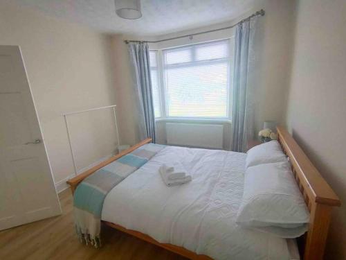 a bedroom with a large bed with a window at Bluebell Cottage Portrush in Portrush
