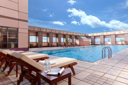una piscina en un hotel con mesas y sillas en The Splendor Hotel Taichung en Taichung