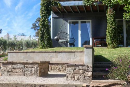 a house with a bench in front of it at Mortimer's Wines Studio - Adults Only Retreat in Orange