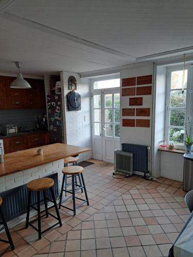 une cuisine avec un comptoir et des tabourets dans une pièce dans l'établissement Ker Manou St Cast le Guildo 900m des plages et du Golf, à Saint-Cast-le-Guildo