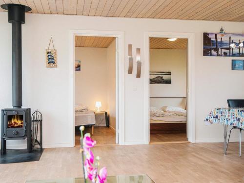 a living room with a fireplace and a bedroom at 4 person holiday home in Nørre Nebel in Nørre Nebel