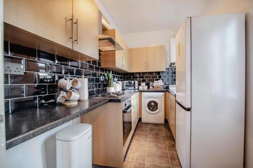 a kitchen with a refrigerator and a washer and dryer at Central Urban Retreat Oasis Free Parking 13ppl in Sheffield