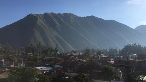 a mountain with a town in front of a city at Hotel Andes de Urubamba in Urubamba