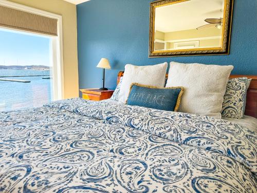 a bedroom with a large bed with a large window at Lakefront Condo Wdockdeckpools-sleeps 6 in Lake Ozark