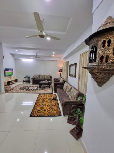 a living room with a couch and a table at Three Bed Attached Bath Netflix Wifi Smart TV Parking WFH Desk in Islamabad