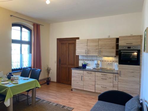 a kitchen with wooden cabinets and a table with chairs at Haus H&M Ferienwohnung 4 in Rehfelde