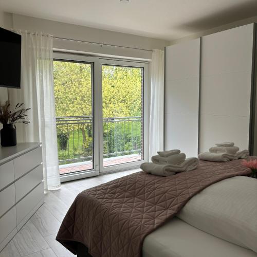 a bedroom with a bed and a large window at Ferienhaus Roomina in Werlte