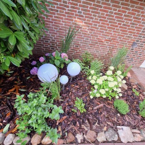 a garden with two blue bird statues in the ground at Ferienhaus Roomina in Werlte
