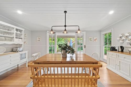 a kitchen with a wooden table and a dining room at Brechin Cottage in Blackheath