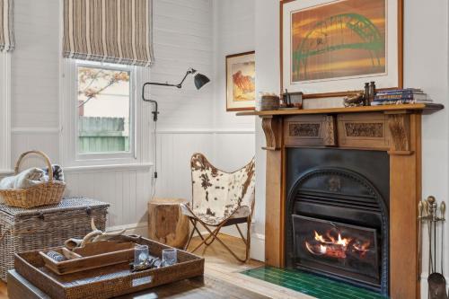 a living room with a fireplace and a chair at Brechin Cottage in Blackheath