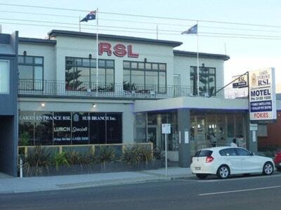 a white car parked in front of a building at Lakes Entrance RSL Glenara Motel in Lakes Entrance