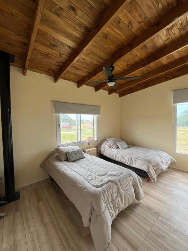 due letti in una stanza con soffitti in legno di Casa SHANTI a Chapadmalal