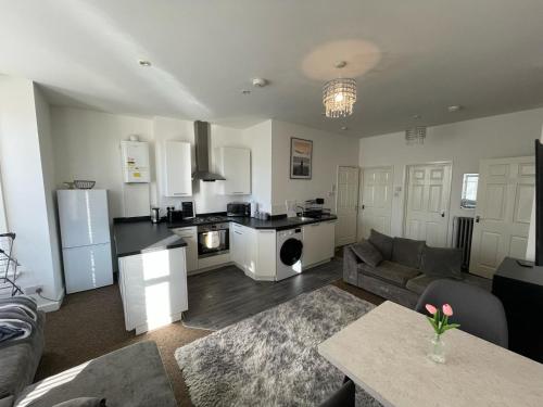a living room with a couch and a kitchen at De'Parys - Sleeps 6! Great for large group of people in Bedford