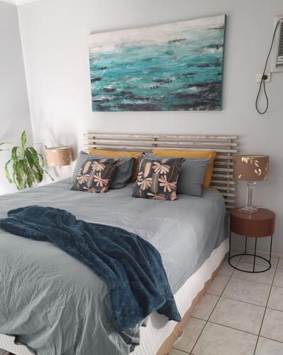 a bed with a blue blanket on it in a bedroom at Barefoot Bungalow 23 Lake Bennett -private pontoon in Lake Bennett