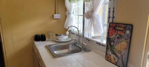 a sink in a kitchen next to a window at Chelox Panama Airport in Tocumen