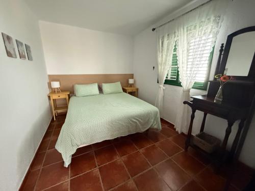 a bedroom with a bed and a chair and a window at Casa Rural La Sombrera in Fasnia