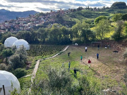 a group of people walking in a field with tents at Domos Cusco Glamping & Nature Lodge in Cusco