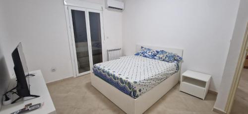 a small bedroom with a bed and a television at Appartement de type F3 in El Kseur