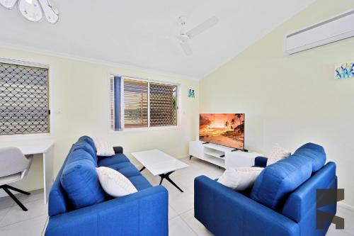 a living room with two blue couches and a table at 6 McColm Court, Bargara in Bargara