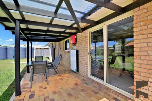 a pergola on a patio with a table and chairs at 6 McColm Court, Bargara in Bargara