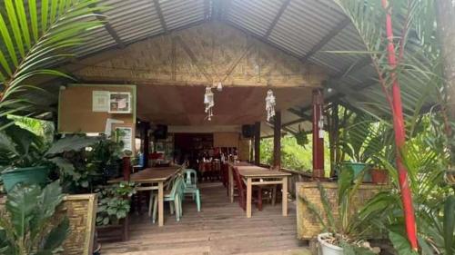 a restaurant with tables and chairs and plants at Little Bridges in Mambajao