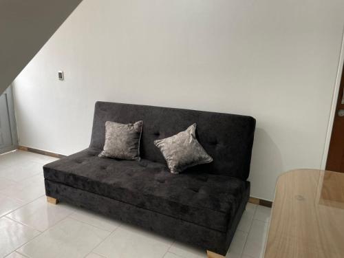 a couch in a living room with two pillows on it at Apartamento independiente en casa familiar Fusagasugá in Fusagasuga