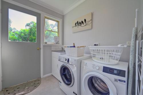 a laundry room with a washing machine and a window at Country House Retreat in Nungurner