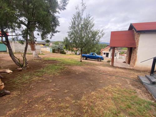 a blue truck parked in a yard next to a house at Cabañas lindo amanecer in Huasca de Ocampo
