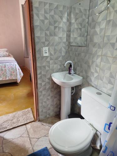 a bathroom with a toilet and a sink at Chalé do Ypê 2 in Pirenópolis