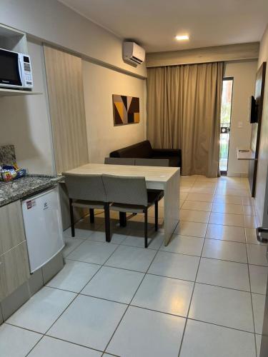 une cuisine et un salon avec une table et un canapé dans l'établissement Apartamento no Barretos Country, à Barretos