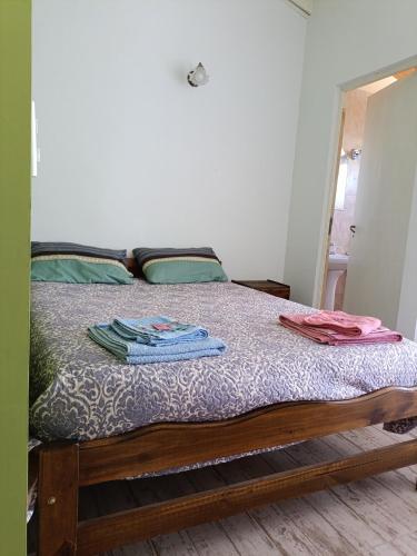 a bedroom with a bed with clothes on it at Departamento Las Margaritas in Malargüe