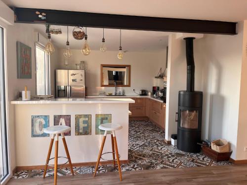 - une cuisine avec une cuisinière et deux tabourets de bar dans l'établissement House in Lacanau near Beaches & Lake, à Lacanau