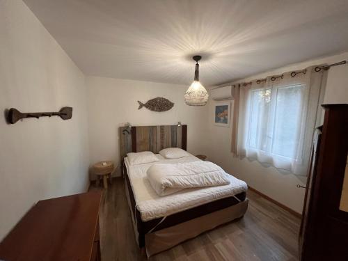 - une chambre avec un lit et une lampe pendant dans l'établissement House in Lacanau near Beaches & Lake, à Lacanau