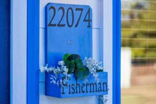 a blue sign with a plant in a blue box at Cape Charles Tiny Livin' in Cape Charles