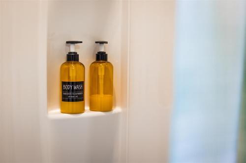 two bottles of yellow liquid sitting on a shelf at Cape Charles Tiny Livin' in Cape Charles